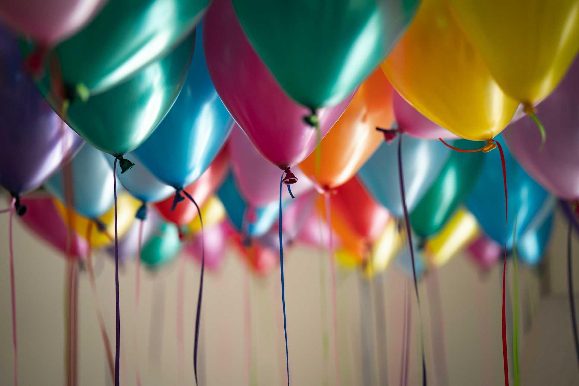 Colorful balloons floating against a neutral background