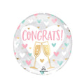 Round balloon with a transparent background featuring CONGRATS! in pink text on a white heart, next to 2 gold champagne glass shapes and lots of pink, white and turquoise hearts.