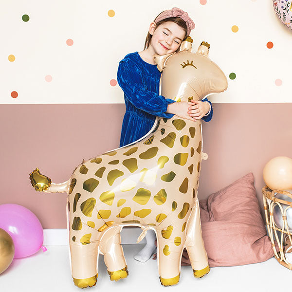 Child hugging a large inflatable giraffe balloon