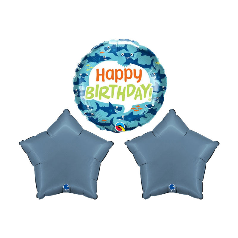 Smiling shark balloon with happy birthday on it, next to 2 satin blue star balloons.
