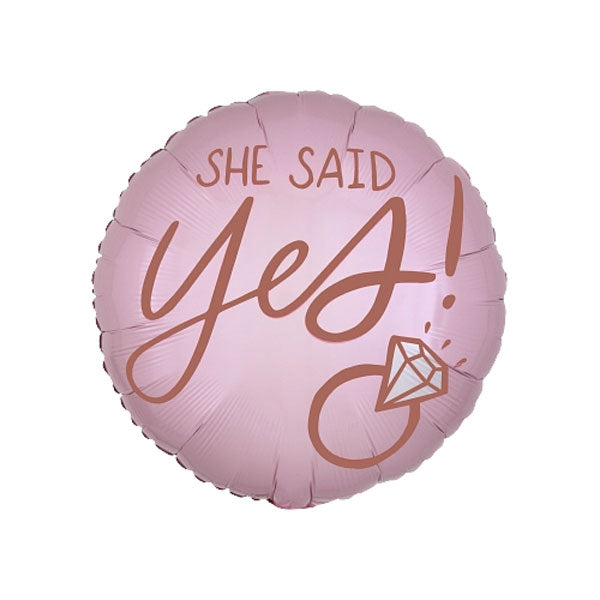Pink balloon with 'She said yes!' in gold writing next to an icon of a diamond ring